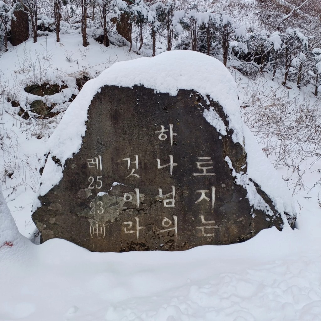눈 덮인 바위에 새긴 「토지는 하나님의 것이라」